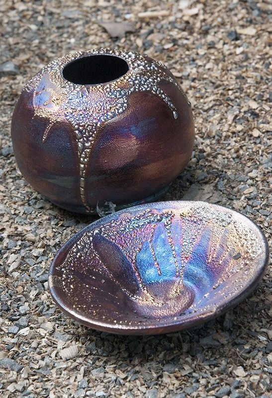 Deux pièces en céramique raku aux reflets métalliques sur des copeaux